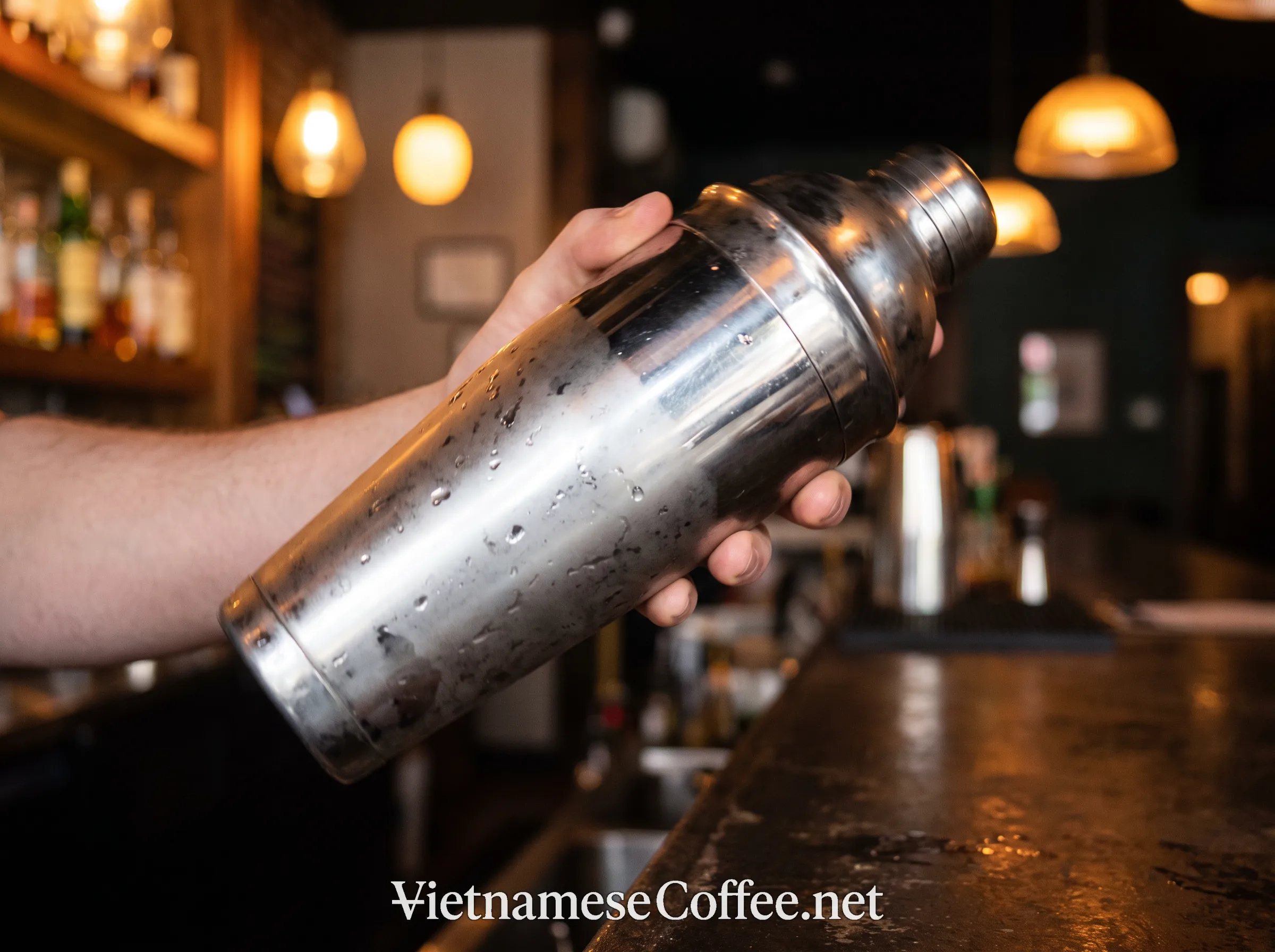 A cocktail shaker being shaken with coffee, vodka, and condensed milk